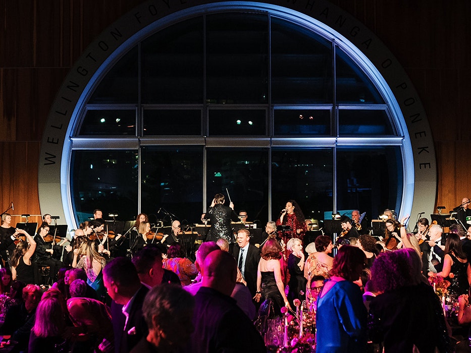 Spring Soiree, 2024. Photo by Anaru Church. Te Papa (247954) A large group of people at a party in a large foyer with a round window at the back.
