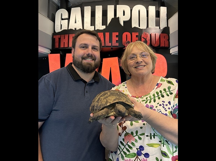 Malcolm Little and Christine Little with Torty. Photo by Tia Nepia-Su'a. Te Papa A man and a woman stand in front of Gallipoli the scale of our war gallery at Te Papa. The woman is holding a live tortoise.