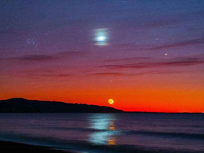 Matariki Herenga Waka. Photo by Richie Mills A sun at sunrise, with a blurry moon.