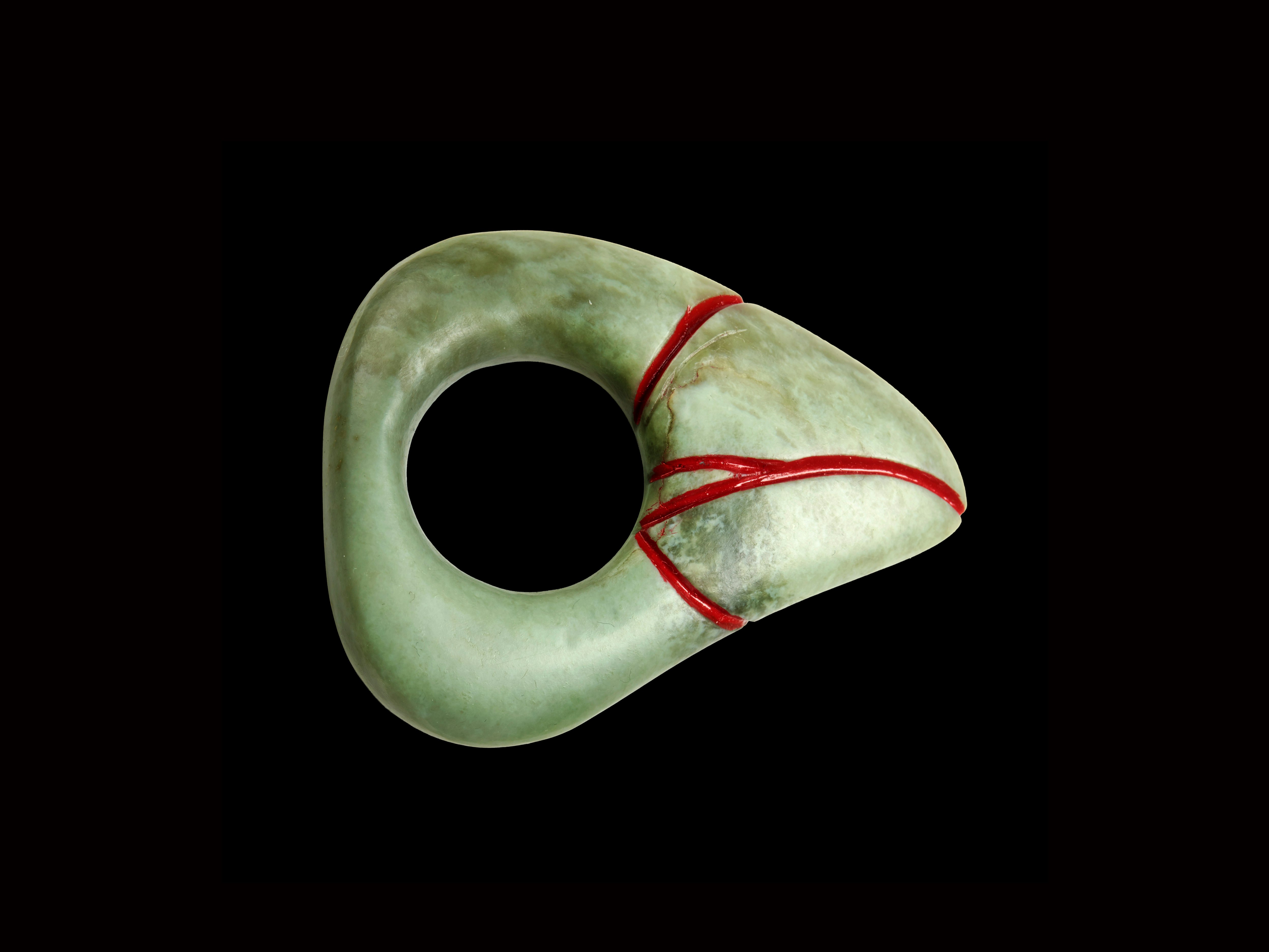 Neke Moa, Kei hea te komako e ko, 2014; New Zealand. Purchased 2015. Te Papa (2015-0016-1/15-20) Pounamu ring in the shape of a triangle with a hole in the centre, and red-painted lines on the main corner.