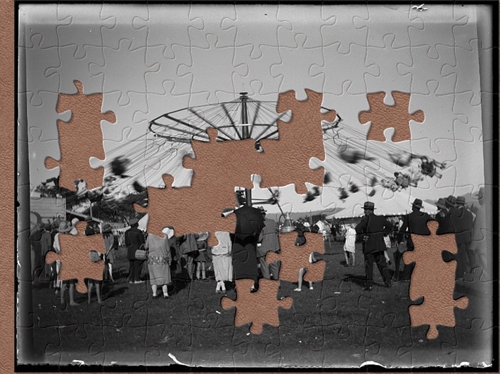 Carousel 'Chairoplane', Levin A&P Show, 25 January 1927, Levin, by Leslie Adkin. Te Papa (A.008555) A black and white photo of a fairground ride with jigsaw shapes missing.