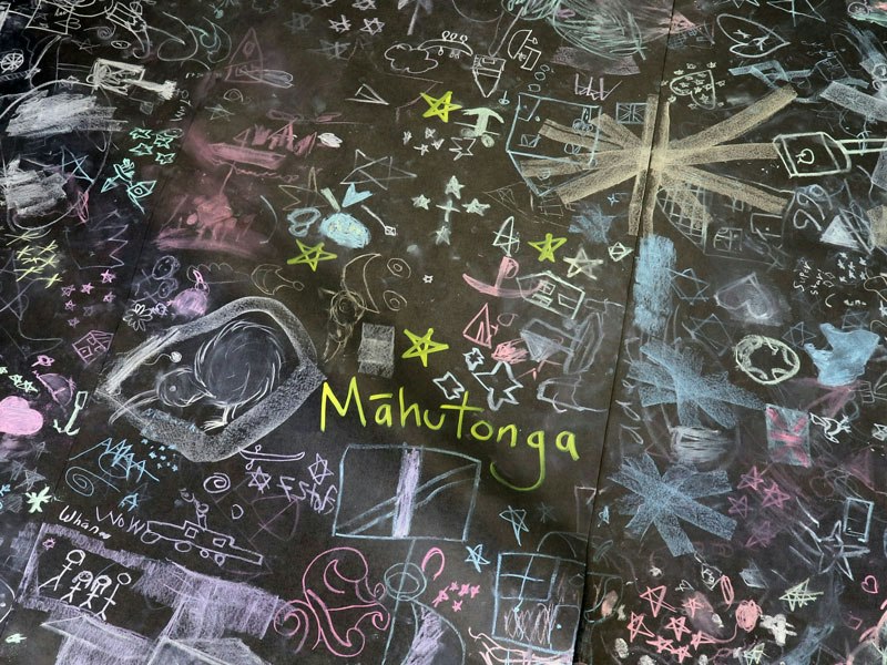 Chalk drawings connected with the constellation Māhutonga (Southern cross) by kids at Expressions Whirinaki Arts and Entertainment Centre, 2019. Te Papa A black surface with chalkl drawings on it.