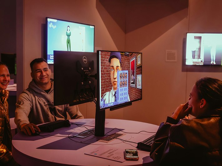 Game Worlds, 2025, ACMI. Photo © Matto Lucas. Three people are sitting in front of computer monitors playing games.